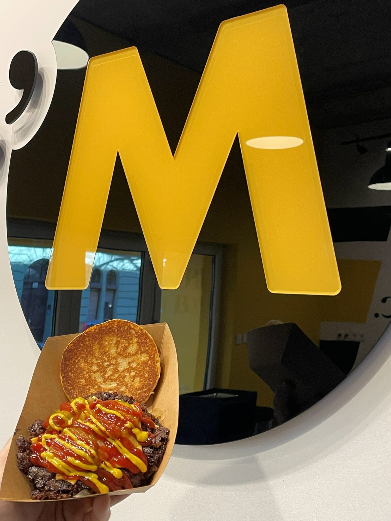 A burger'M étterem belső tere, a falon nagy sárga M betű kör alakú tükörben